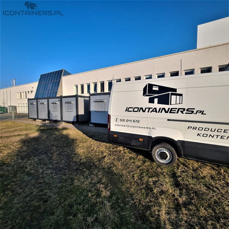 Samochód iContainers obok kontenerów