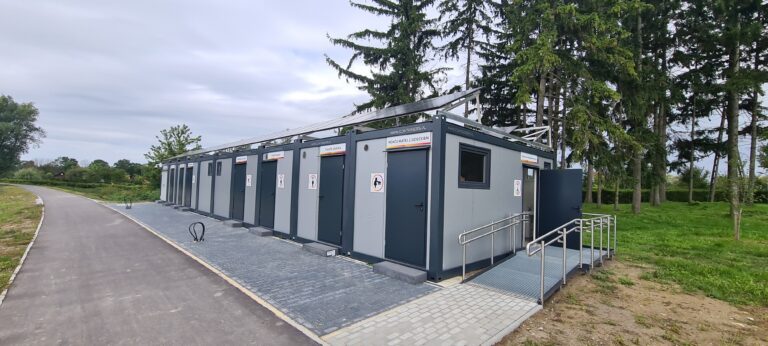 Kontenery z oddzielnymi wejściami ustawione przy drodze